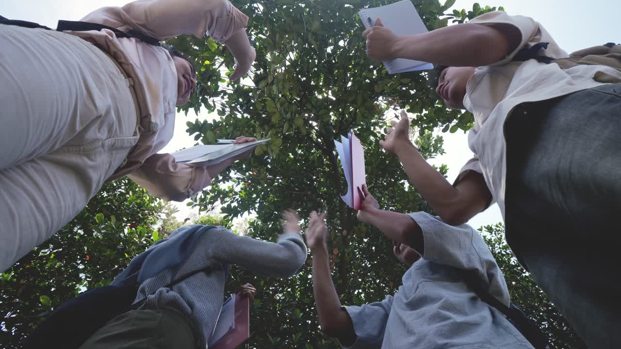 Low Angle Shot Of Happy Teenage People Stacking Hands Together And Giving High Five To Each Other Showing Teamwork And Cooperation