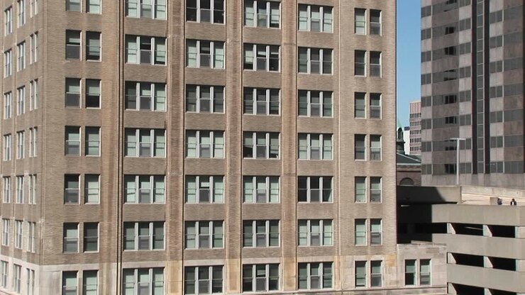 Zoom sulle finestre di un vecchio edificio per uffici per mostrare le tende storte