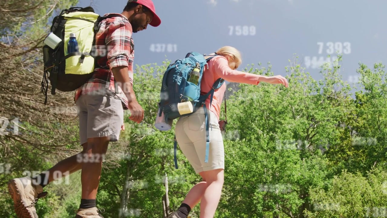 Donna che scende da una sporgenza per attraversare in sicurezza, seguita da un uomo, con una sovrapposizione numerica che traccia pacchi all'aperto