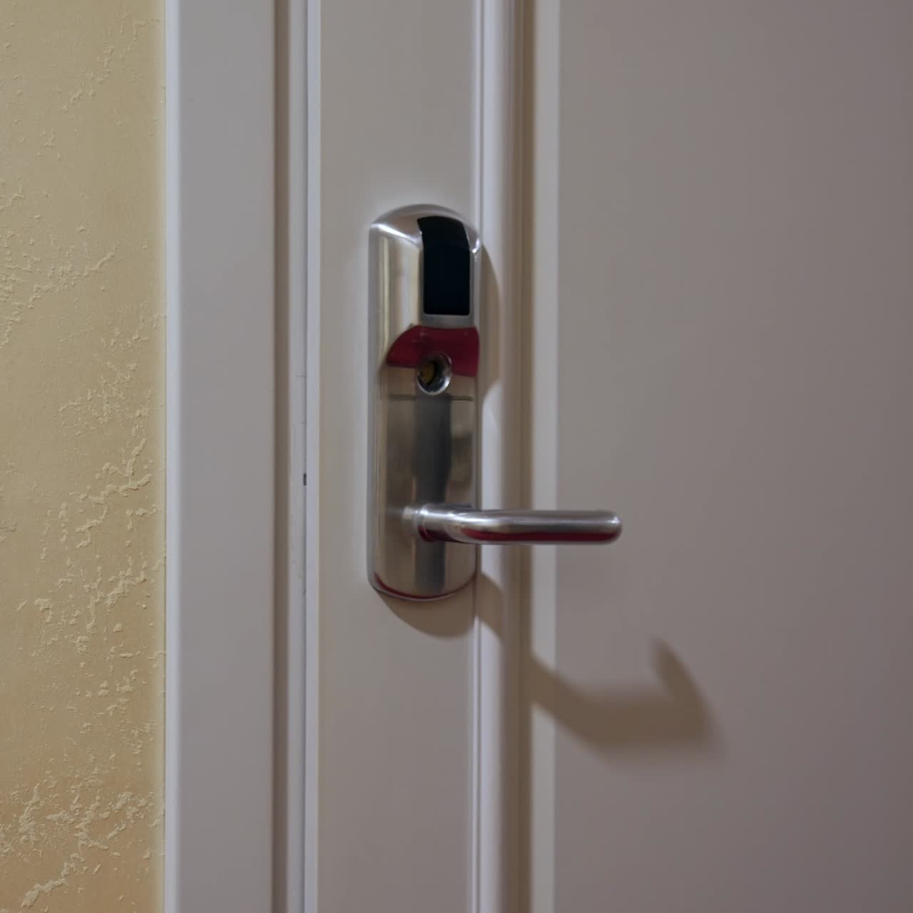 Hotel door with digital lock. Female hand puts the keycard to the electronic sensor and then opens the door