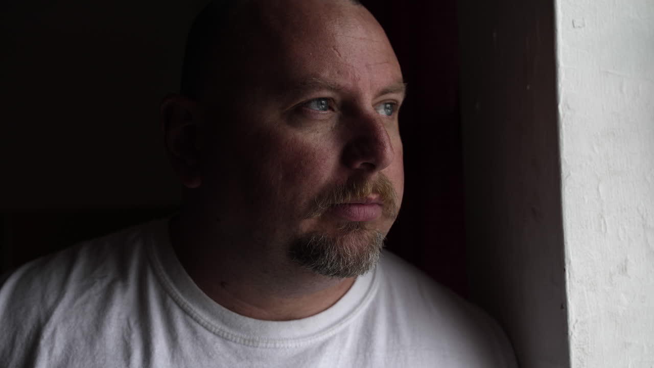 hombre de aspecto serio profundamente en pensamiento y contemplación mirando hacia afuera