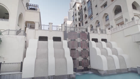 Dubai-city-fountain-with-buildings-and-futuristic,-traditional-architecture