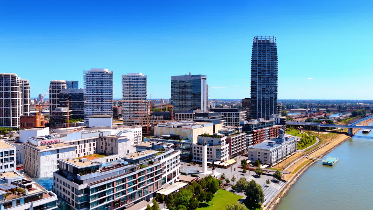Bratislava skyline by the river. Stunning skyline of Bratislava under clear blue skies, showcasing modern architecture along the tranquil riverbank