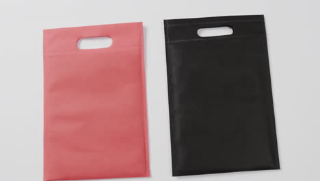 close up of red and black bags on white background, copy space, slow motion