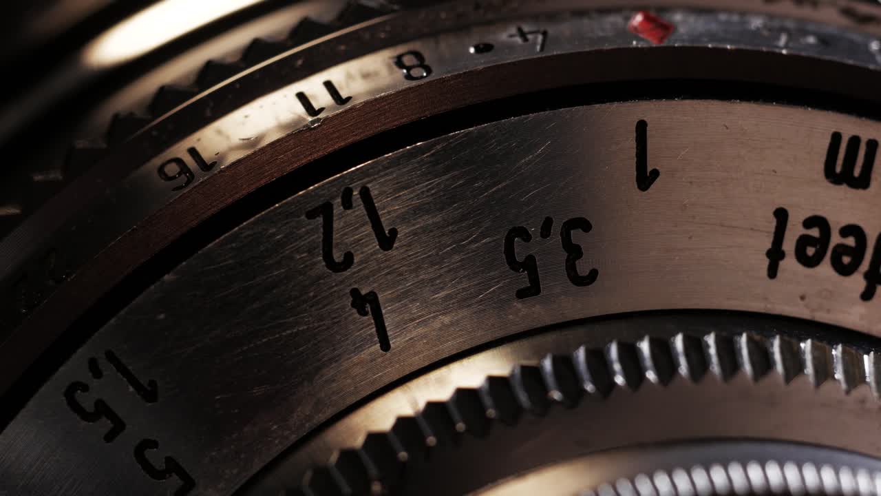 Close up of vintage metal lens focus wheel clicking to infinity with wooden-tone lens ring
