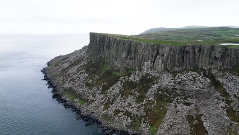 tomada aérea de paralaje de la geográficamente prominente fair head en irlanda del norte conocida por sus impresionantes acantilados costeros y vistas panorámicas para excursionistas y escaladores a primera hora de la mañana