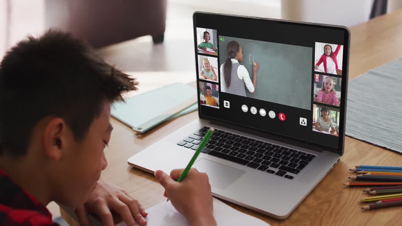 niño asiático haciendo la tarea y teniendo una videoconferencia con el maestro y sus compañeros de clase en la computadora portátil en casa