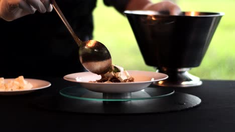 hands with a spoon putting mexican soup in a bowl