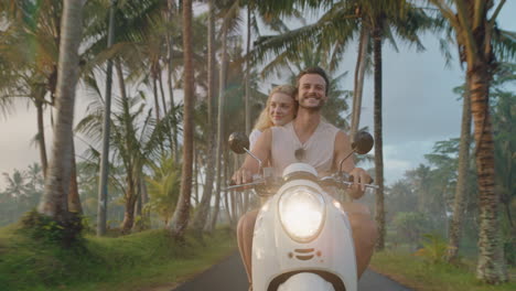 pareja feliz montando un scooter en una isla tropical mujer feliz celebrando con los brazos levantados disfrutando de una aventura romántica con su novio en un paseo en motocicleta en la niebla de la mañana