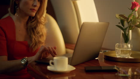 Luxury-ceo-working-laptop-on-corporate-trip-closeup.-Focused-blonde-drink-coffee