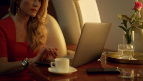 luxury ceo working laptop on corporate trip closeup. focused blonde drink coffee