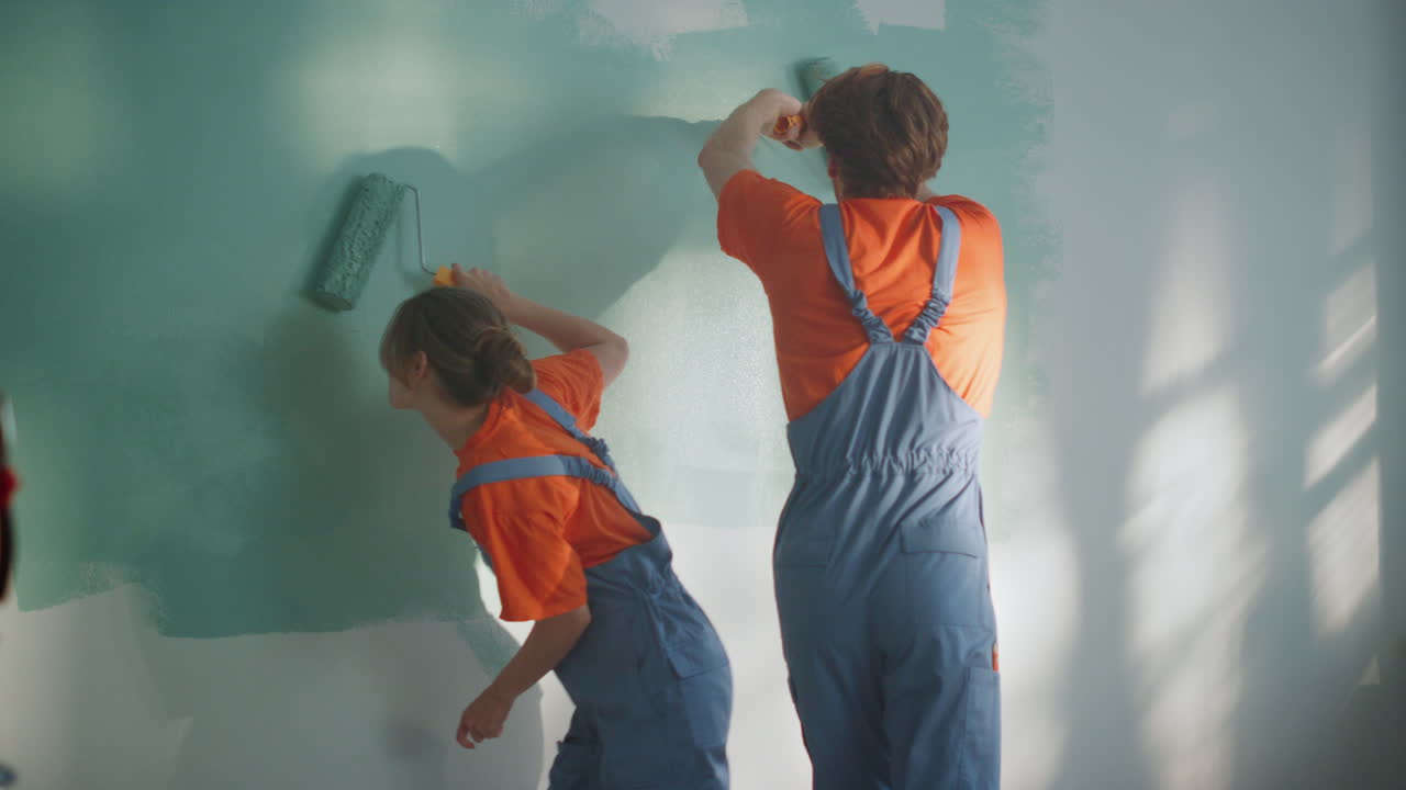 una pareja feliz trabajando en la renovación de la casa. pintura familiar con diversión en el interior.