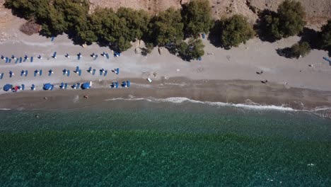 top down tilting aerial view of beautiful beach in south crete, revealing dramatic cliffs of sfakia area in the mediterranean sea