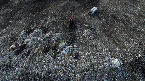 aerial view of a landfill with garbage trucks