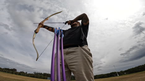 An-archer-shoots-multiple-arrows-in-a-row-at-an-archery-range