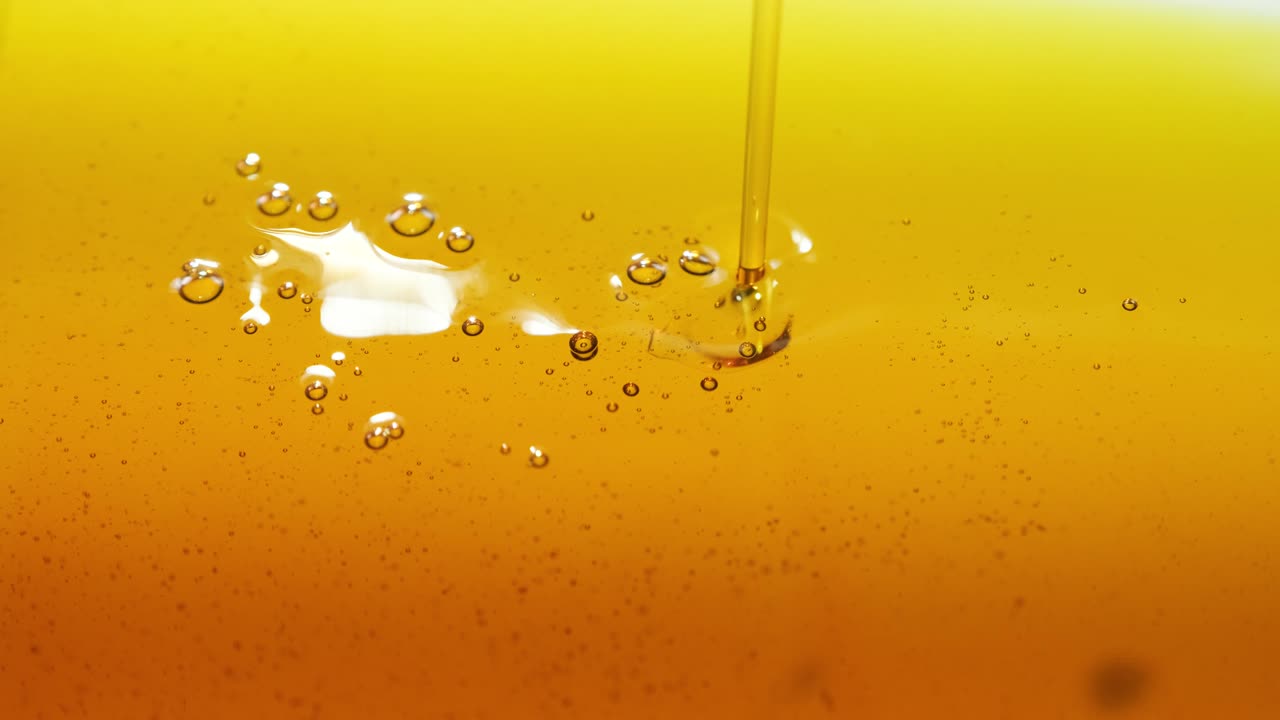 verter aceite en el motor del coche o oliva cocción de verduras y burbujas aisladas. verter miel. cámara lenta