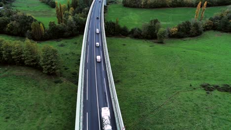 vista aérea sobre maravillosas carreteras en francia. sólo campos de hierba y árboles alrededor de las carreteras. coches y camiones conduciendo en las carreteras bajo el sol.