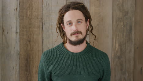 portrait of young man smiling running hand through dreadlocks hairstyle smiling looking at camera blue eyes real people series