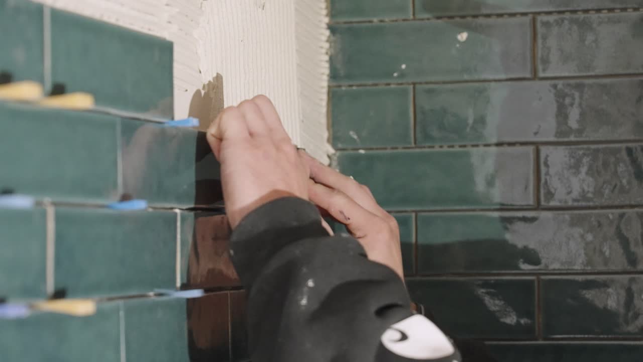 Firmly tapping a tile into place to make sure it is secure