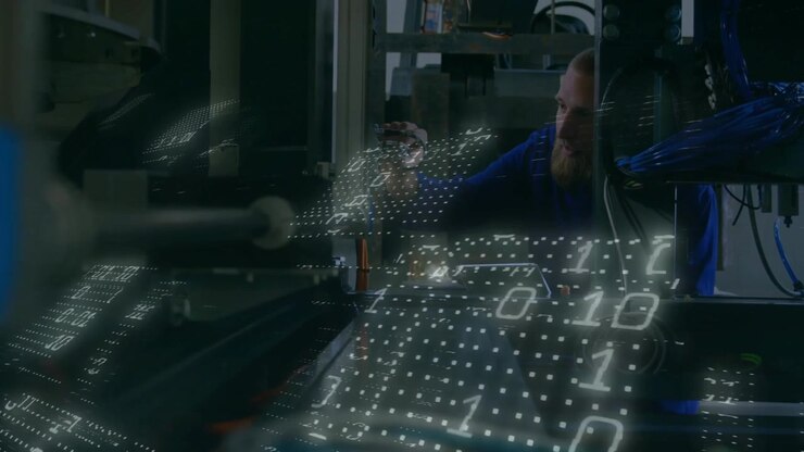 Technician reaching into machine lifting sensor calibrating pins for data flow overlay flowing