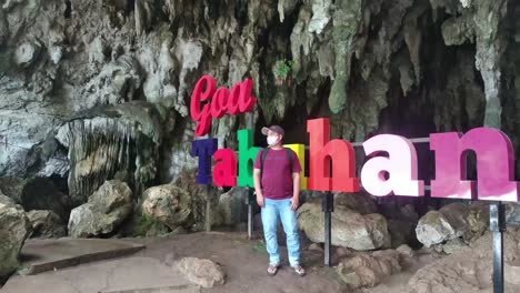 Visitors-standing-in-front-of-Tabuhan-Cave-in-Pacitan,-East-Java,-Indonesia