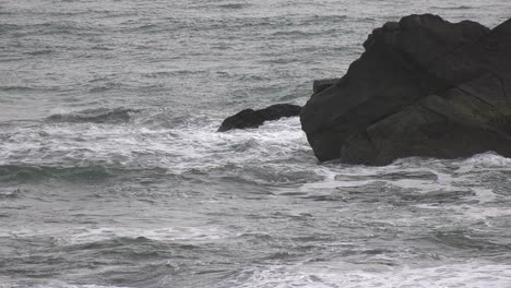 waves-crash-against-beach-and-rocks