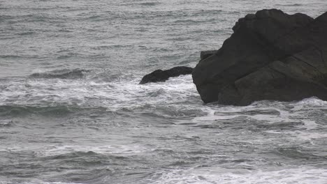 las olas chocan contra la playa y las rocas