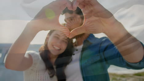 animation of waving flag of argentina over couple having fun on the beach