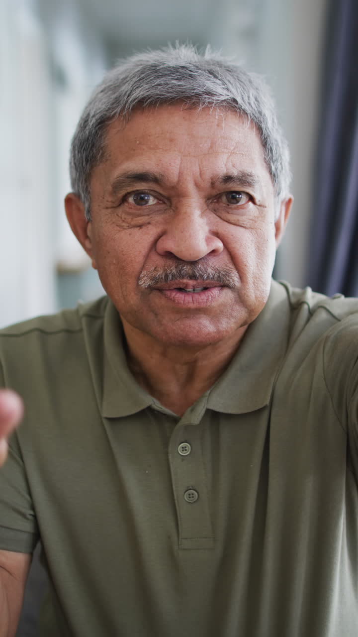 Vertical video of portrait of happy senior biracial man talking