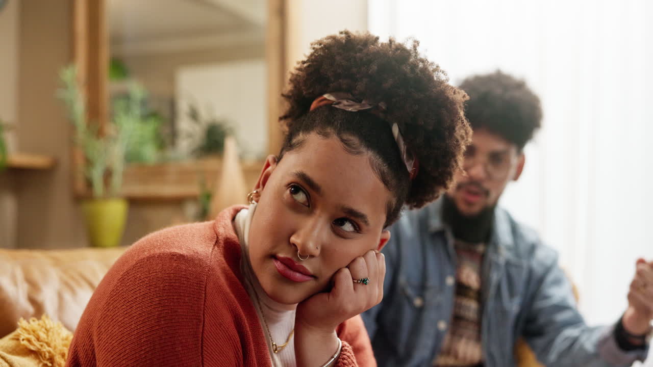 A young couple is arguing in their living room.