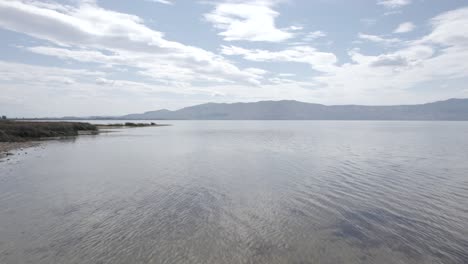 Video-with-a-drone-on-Lake-Skadar-in-Albania,-on-an-old-wooden-boat-in-the-foreground,-surpassing-it-in-different-planes-at-water-level