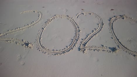 extreme push in to twenty twenty written in the sand