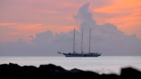 yacht at anchor against a backdrop of golden clouds at dusk