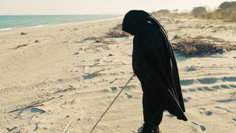 elderly and mysterious sorcerer carving symbols into the sand