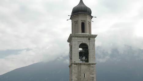 primer plano de las campanas doblando en la torre de la iglesia de san benedetto, cerca del lago de garda, italia