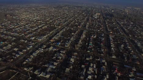 Neigen-Sie-Die-Drohnenkamerabewegung-An-Einem-Sonnigen-Morgen-Auf-Die-Stadt-Karakol