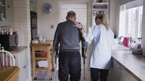 elderly man assisted by nurse in kitchen