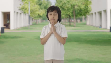 공원에서 하나님께 기도하는 귀여운 인도 소년