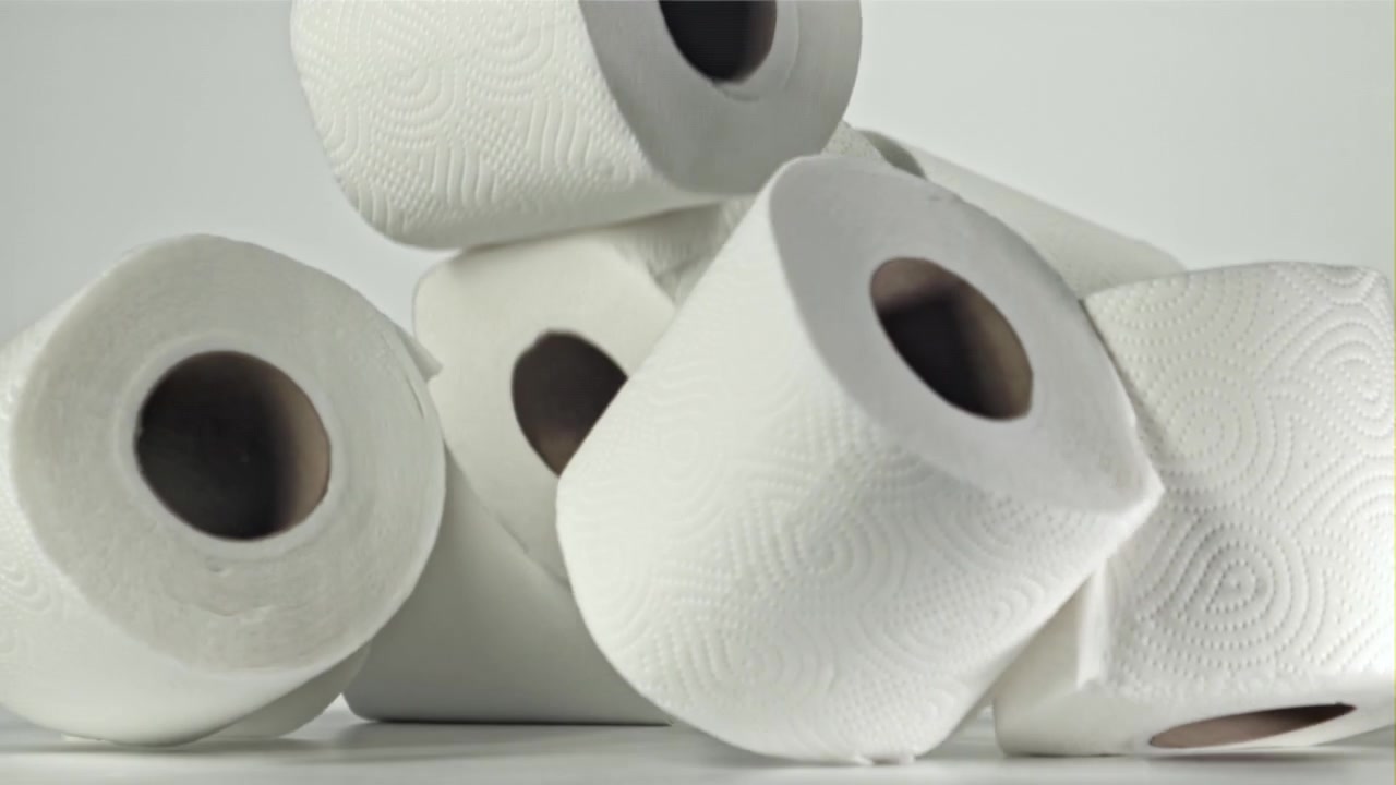 Toilet Paper Rolls Falling in Slow Motion on White Background
