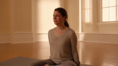 woman crying while sitting on a yoga mat