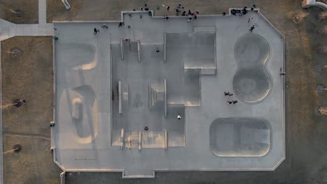 aerial view above people biking in a skate park, sunset in california - top down, drone shot