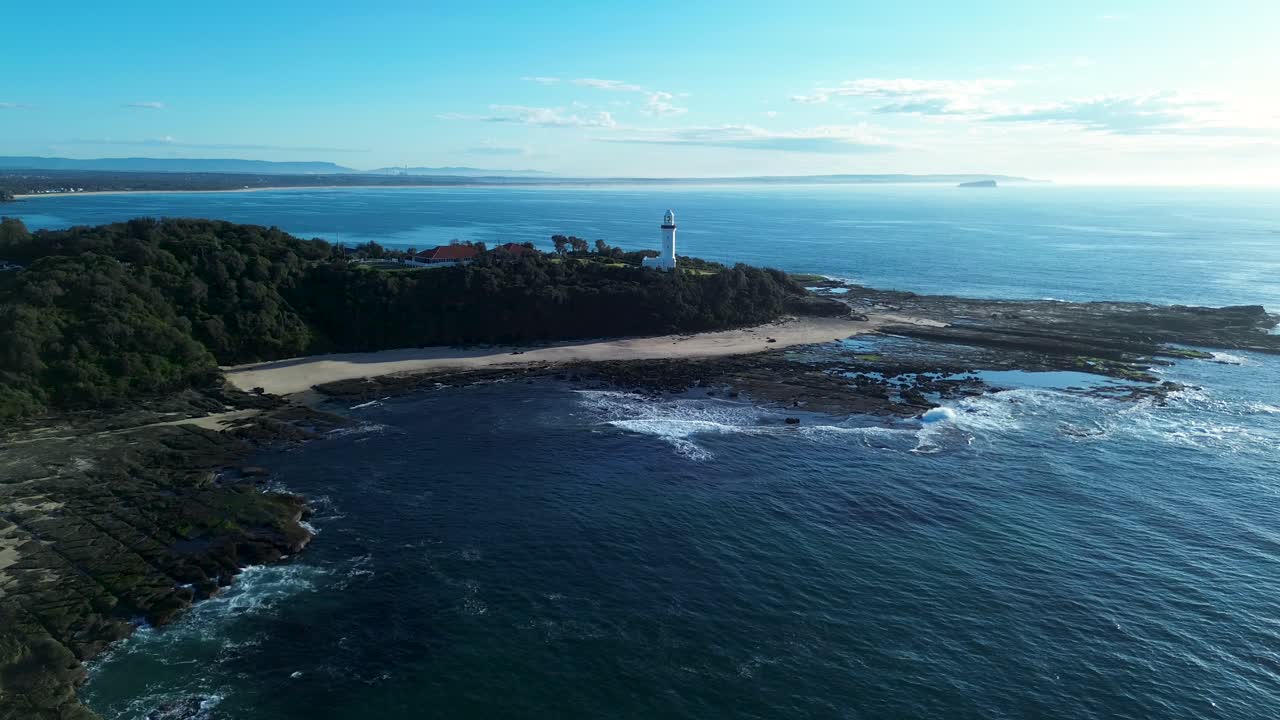 Drone aerial landscape view of Norah Head lighthouse Toukley rock headland coastline ocean sandy beaches nature bushland sea Central Coast Australia