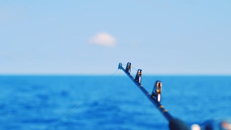 close up on fishing wire running through rod with soft focus ocean background