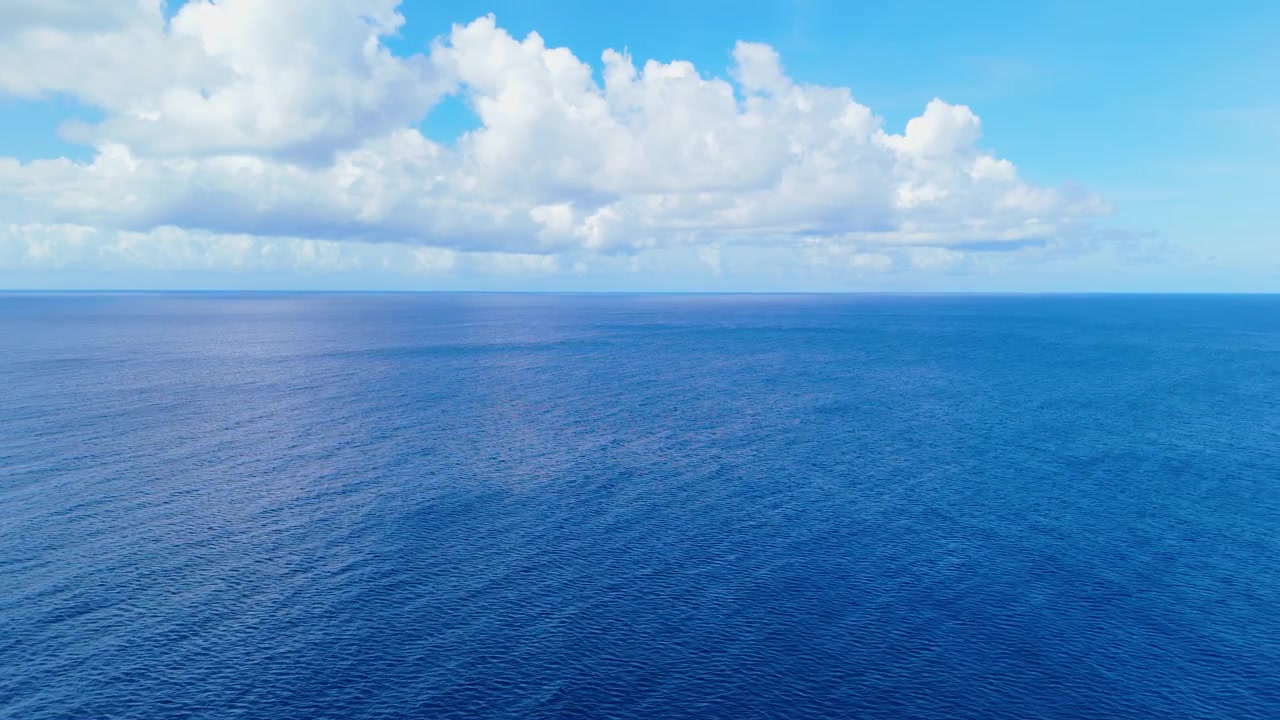 Carrellata panoramica con drone di acque oceaniche calme sotto cieli sereni a Playa Manzaliña, con costa tropicale visibile