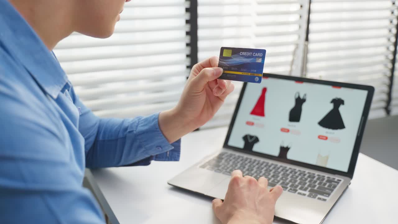 아시안 남성은 쇼핑을 위해 노트북 컴퓨터를 사용합니다. 온라인으로 상품을 판매합니다. 매력적인 잘생긴 남자는 신용카드를 손에 들고 스마트폰에서 웹 사이트에서 상품을 구매하고 구매합니다. 전자 상거래 개념.