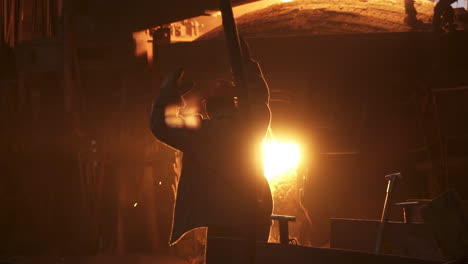 metalúrgico vertiendo metal fundido en una fundición