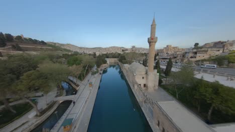 advancing aerial drone footage extreme fast flying around sheyh ali dede turbesi, near the urfa in sanliurfa city, turkey. exiting footage shot with fpv racing drone aerobatic