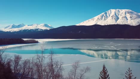 Vídeo-De-4.000-Drones-De-Montañas-Cubiertas-De-Nieve-Junto-A-Un-Lago-En-Alaska-Durante-El-Invierno