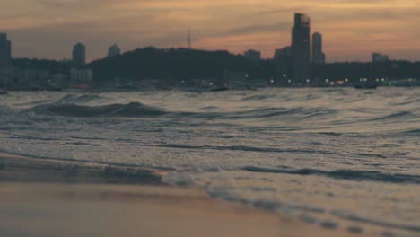 waves roll on beach and barefoot man silhouette in dusk
