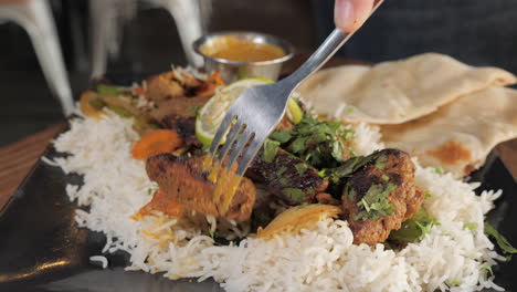 tenedor toma carne de res del plato de kabob con arroz y naan, cierre deslizante de cámara lenta tira 4k